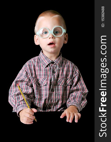 Cute boy with glasses holding a pencil isolated on a black background. Cute boy with glasses holding a pencil isolated on a black background