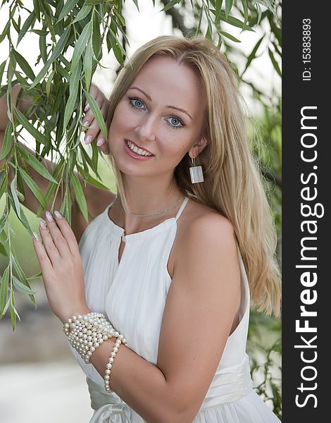 Portrait of happy bride in white dress posing outdoors