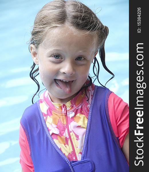 Photo image of a happy little girl in a swimming pool making a funny face. Photo image of a happy little girl in a swimming pool making a funny face