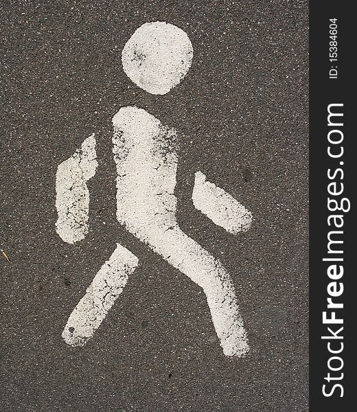 White painted man over black asphalt surface. White painted man over black asphalt surface