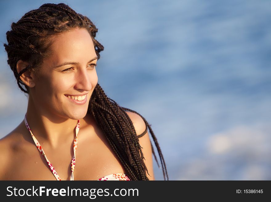 Young beautiful tanned girl smiling in copyspaced composition.