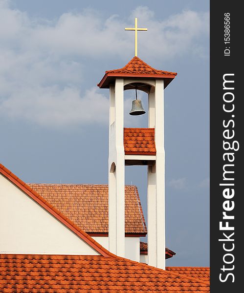 Yellow cross at top of church on blue sky. Yellow cross at top of church on blue sky