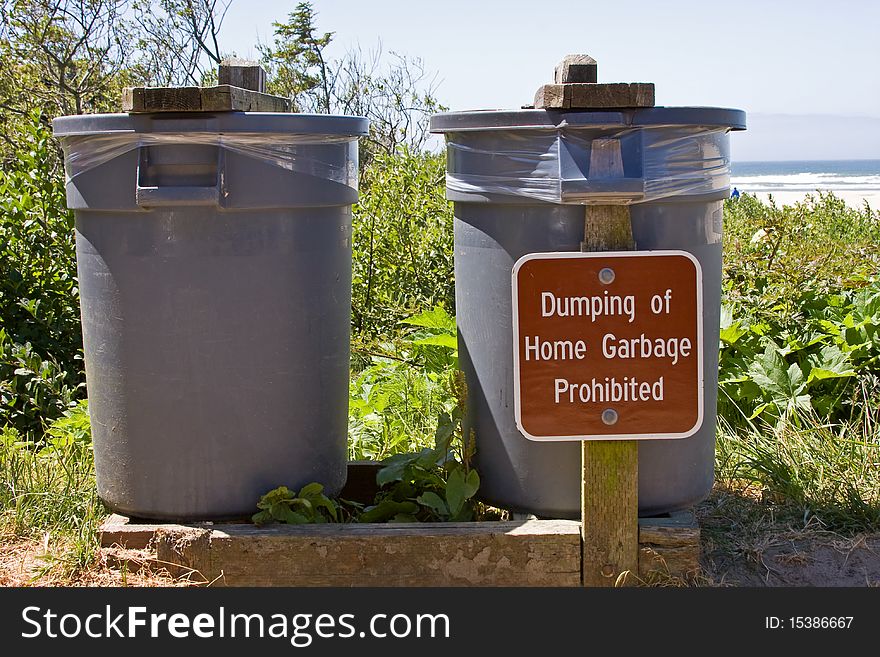 Public trash cans with prohibiting sign.