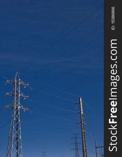 Several electricity posts against blue sky