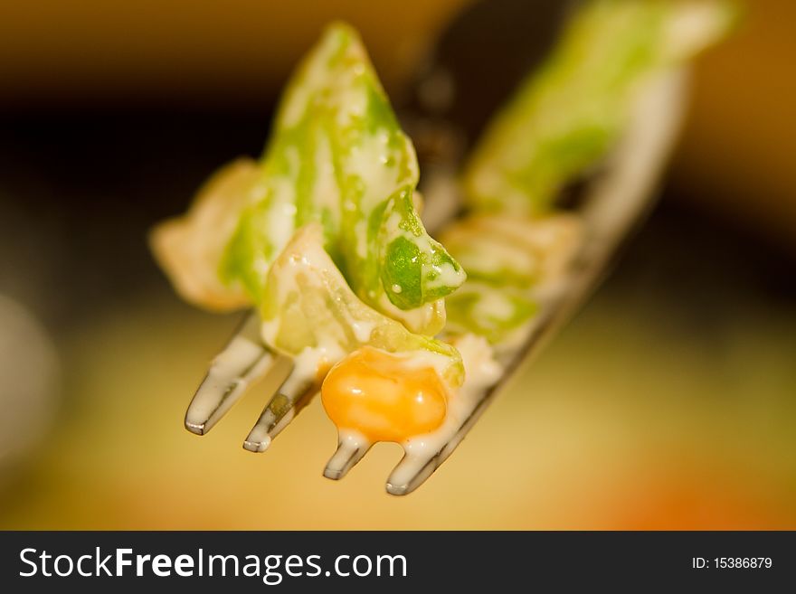 Macro of a fork containing fresh salad with corn and mayonnaise sauce. Macro of a fork containing fresh salad with corn and mayonnaise sauce