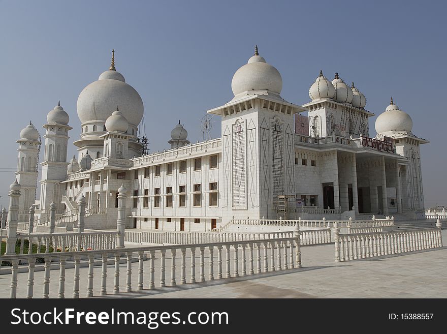 White marble Hindu temple on a cloudless day