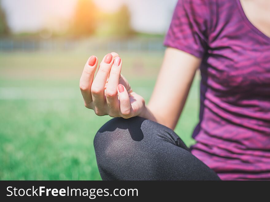 Young woman practicing morning meditation in nature at the park. Health lifestyle concept.