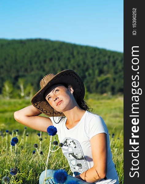 Beautiful slavonic girl in cowboy clothes on a meadow. Beautiful slavonic girl in cowboy clothes on a meadow