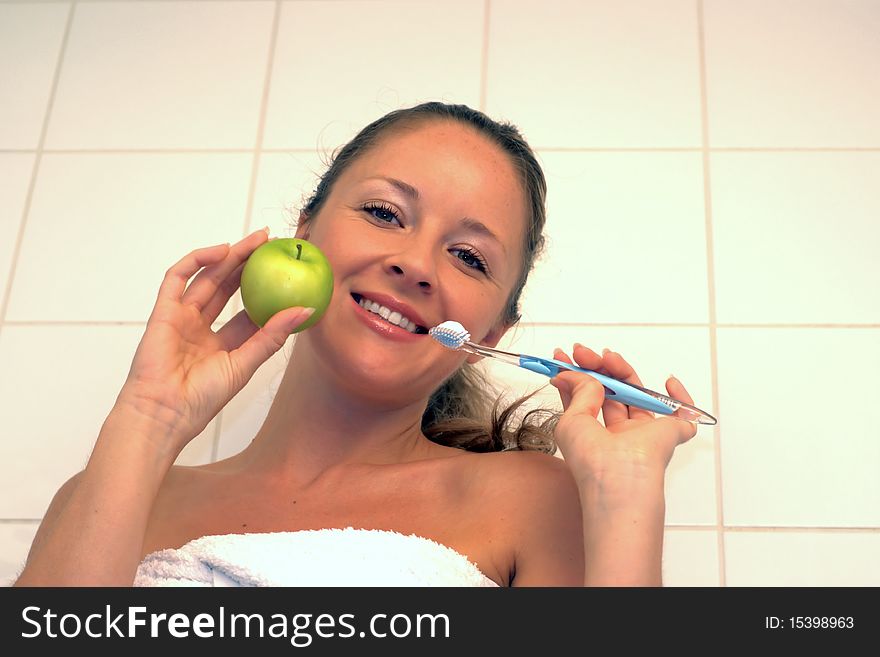 Yuong woman holding green apple and toothbrush. Yuong woman holding green apple and toothbrush