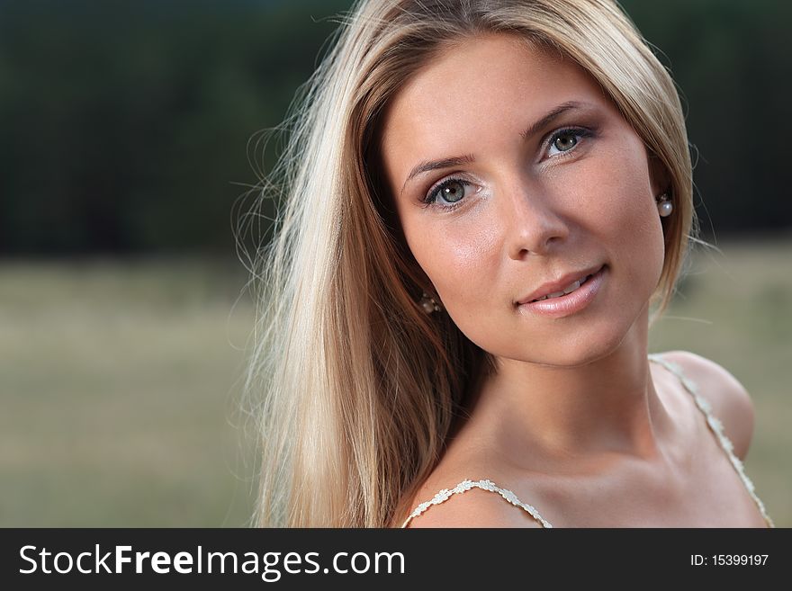 Beautiful young woman posing over green landscape. Beautiful young woman posing over green landscape.