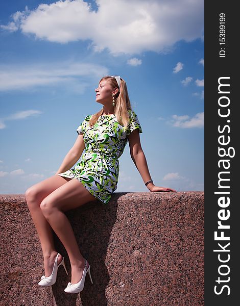 Young beautiful girl resting on the parapet