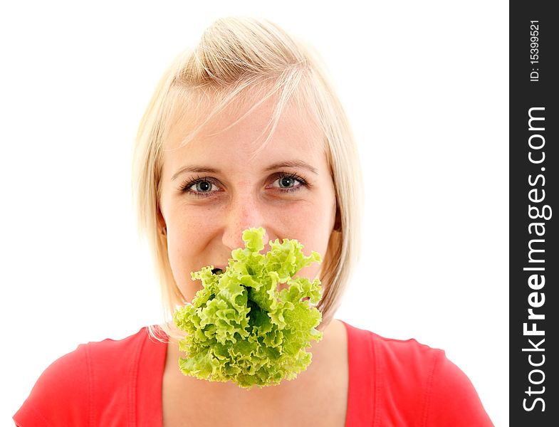 An attractive young vegetarian girl with a lettuce in her mouth over white background. An attractive young vegetarian girl with a lettuce in her mouth over white background
