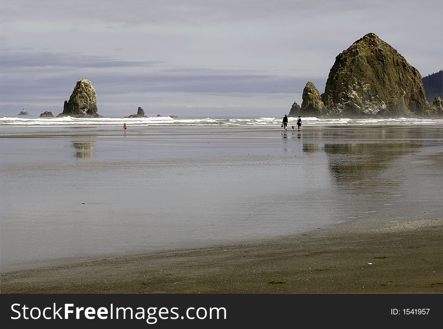 Couple walking on cannon beach, oregon in morning