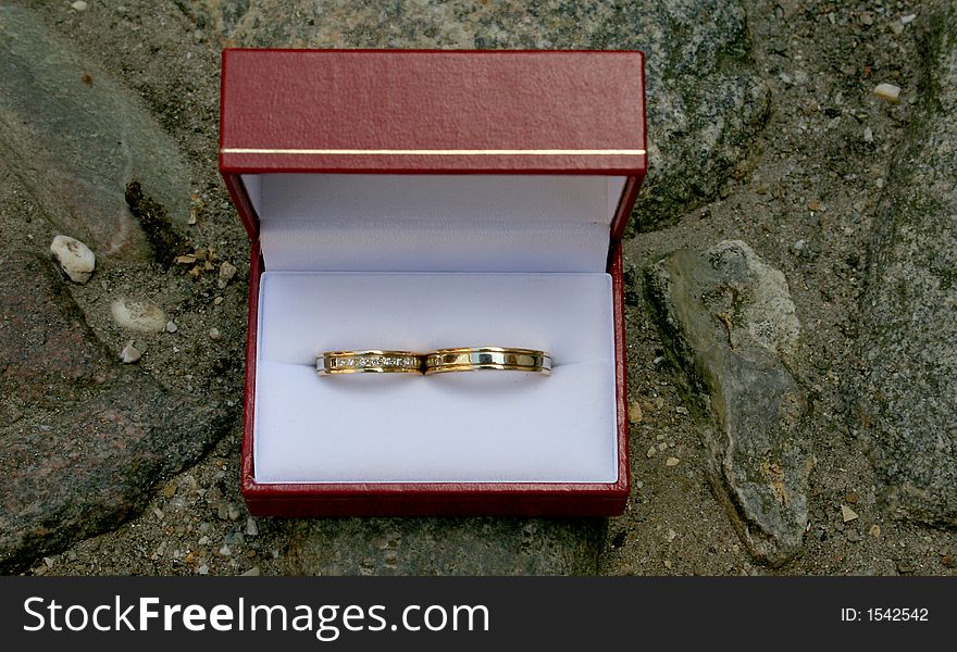 Wedding rings in a red box on stones