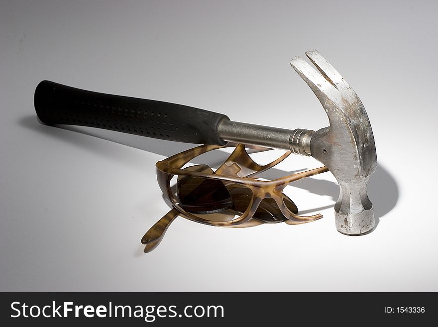 Photo of a Broken Sunglasses and Hammer. Photo of a Broken Sunglasses and Hammer