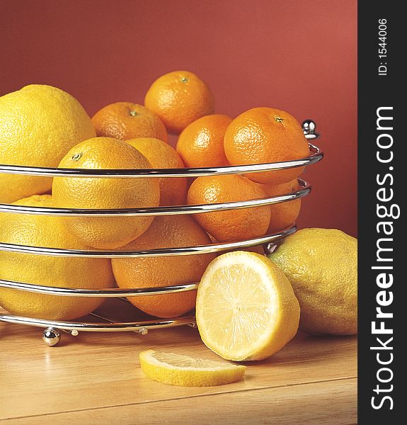 Oranges, satsumas, grapefruits and lemons in a chrome bowl. Oranges, satsumas, grapefruits and lemons in a chrome bowl