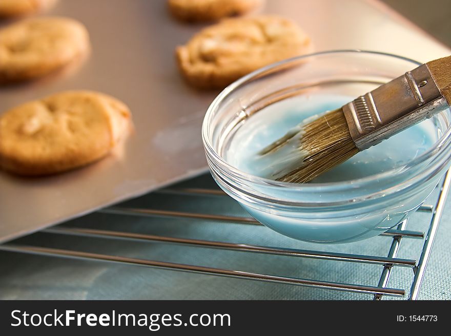 Nut cookies on a baking sheet with confectioners icing and brush. Nut cookies on a baking sheet with confectioners icing and brush