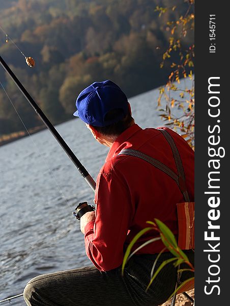 A fisherman looking at the bait, considering its size. A fisherman looking at the bait, considering its size