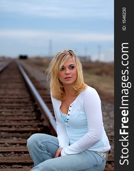 Beautiful young woman on railroad tracks. Beautiful young woman on railroad tracks.