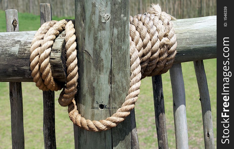 Thick rope securing a wood fence. Thick rope securing a wood fence