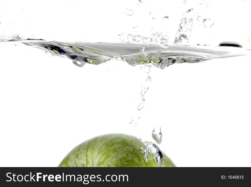 Green apple splashing into water. Green apple splashing into water