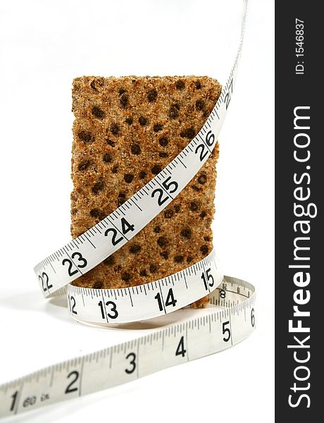 Low calorie rye cracker wrapped in a tape measure. Low calorie rye cracker wrapped in a tape measure.