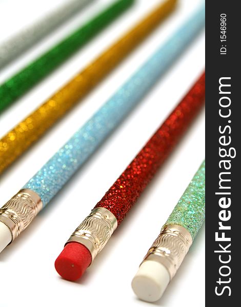 Set of celebratory color pencils with a multi-coloured sparkling covering macro. Set of celebratory color pencils with a multi-coloured sparkling covering macro