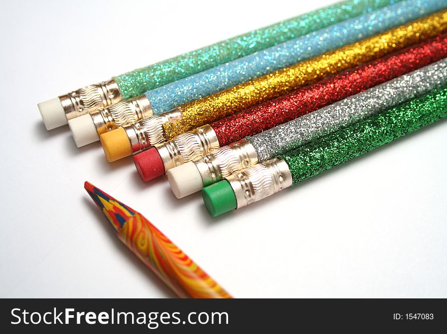 Set of celebratory pencils about a multi-colour pencil on a diagonal