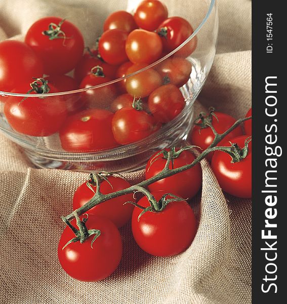 A glass bowl of picked and vine tomatoes. A glass bowl of picked and vine tomatoes