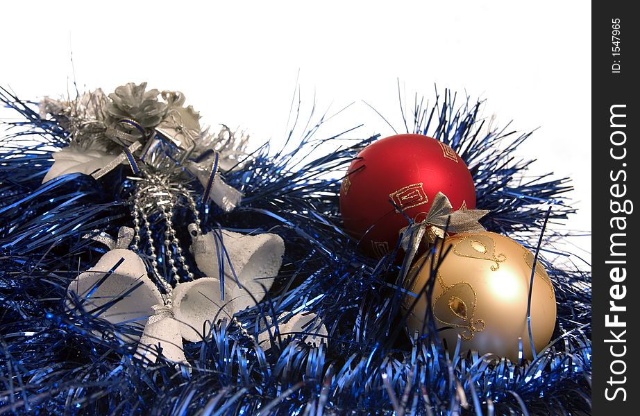 White bells and colour balls lie on blue new-year tinsel