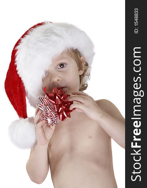 A young child wearing a santa hat and holding two christmas bows. Looking at the camera. Isolated white background. A young child wearing a santa hat and holding two christmas bows. Looking at the camera. Isolated white background