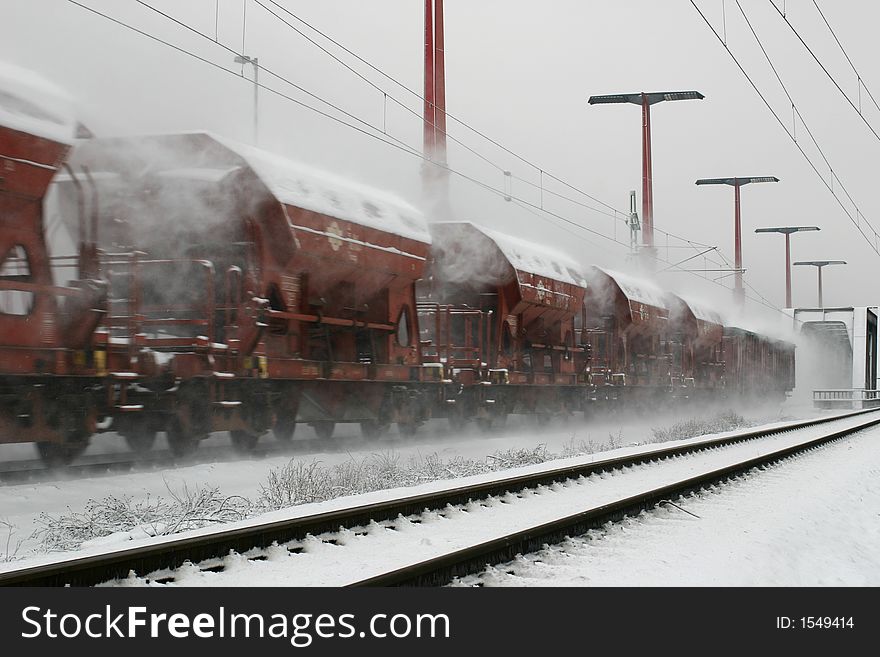 A freight train is clunking in the snow. A freight train is clunking in the snow