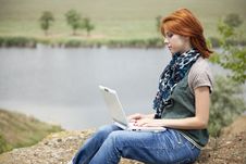 Young Girl With Laptop At Rock Near Lake Royalty Free Stock Photography