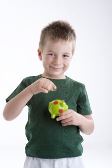 Little Boy Depositing Money In His Piggy Bank. Stock Photography