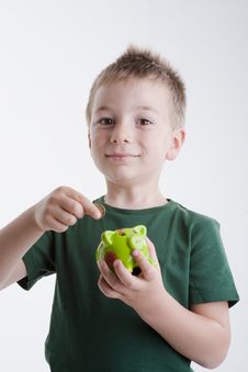 Little Boy Depositing Money In His Piggy Bank. Royalty Free Stock Photography