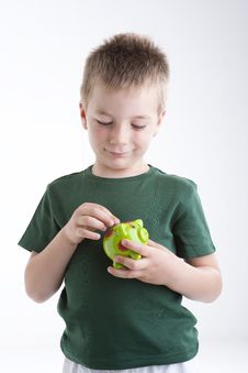 Little Boy Depositing Money In His Piggy Bank. Stock Photos