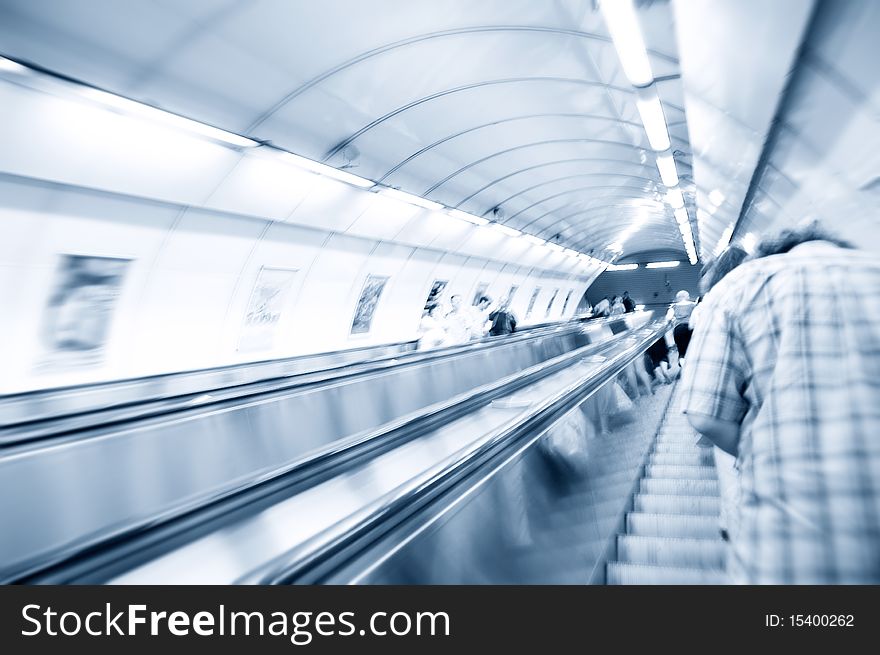 People on escalator in subway. Abstract motion picture.