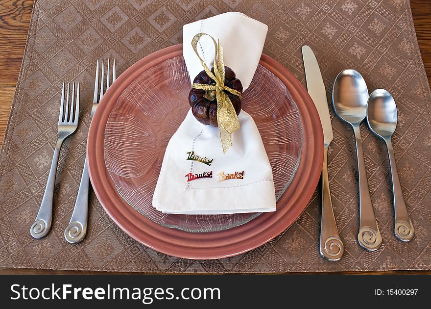 Seasonal Table Setting with napkins, silverware, napkin ring, plates, and plate mat