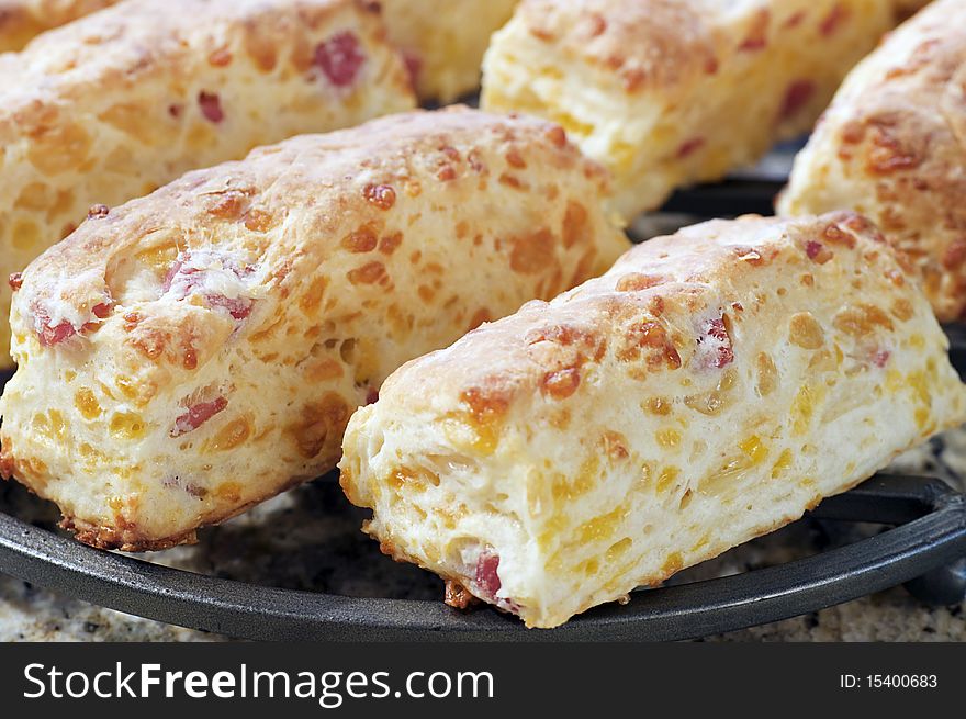 Country style ham and cheese biscuits freshly baked from scratch sit on a cooling rack. Country style ham and cheese biscuits freshly baked from scratch sit on a cooling rack.