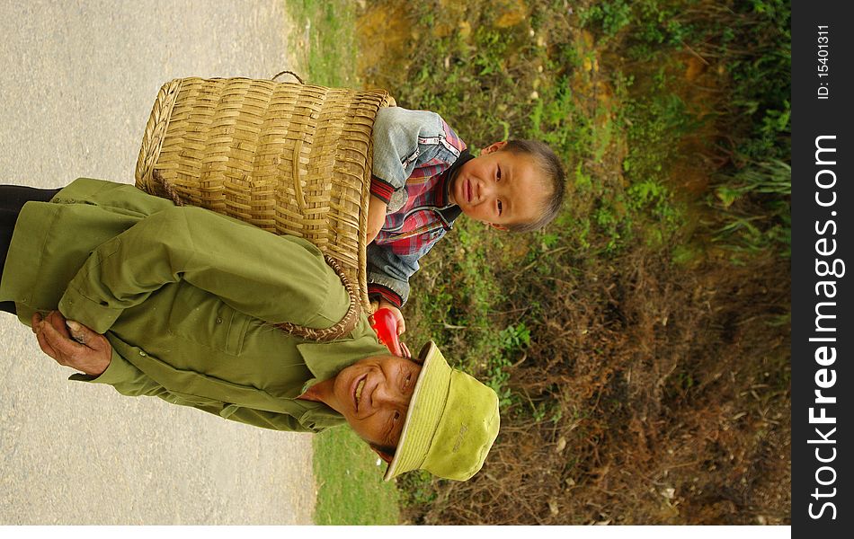 Grandfather Hmong and her small son in the cart. The road is long and the baby is tired. Grandfather Hmong and her small son in the cart. The road is long and the baby is tired.