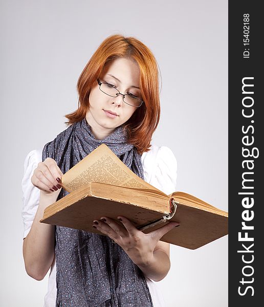 Young doubting fashion girl in glasses with old book. Young doubting fashion girl in glasses with old book