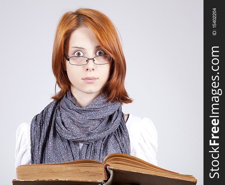 Doubting girl in glasses with old book