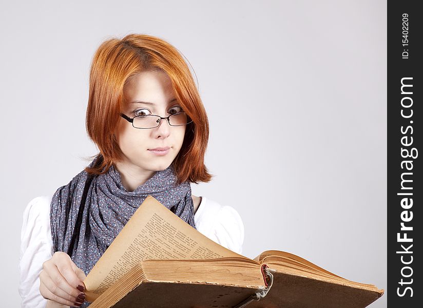 Doubting girl in glasses with old book