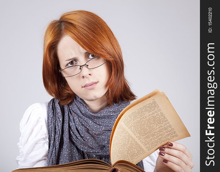 Young doubting fashion girl in glasses with old book. Young doubting fashion girl in glasses with old book