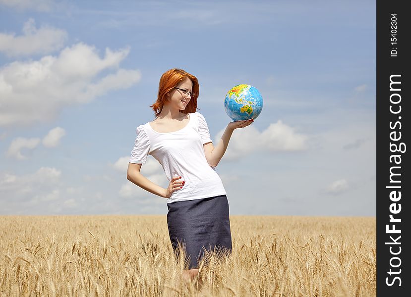 Young Businesswomen in white keeping globe in hand at wheat field