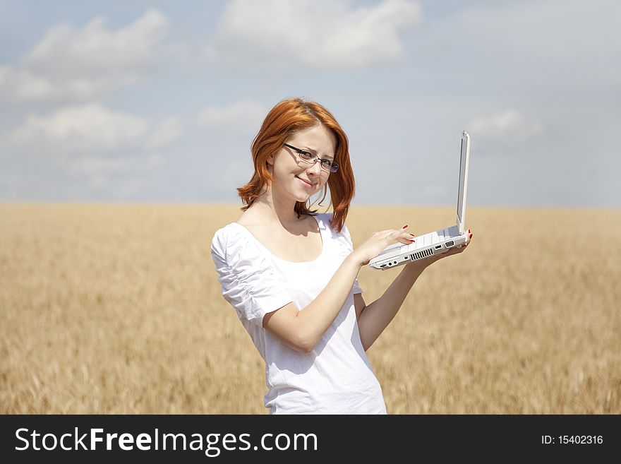 Young Businesswomen in white working with notebook at wheat field. Young Businesswomen in white working with notebook at wheat field.