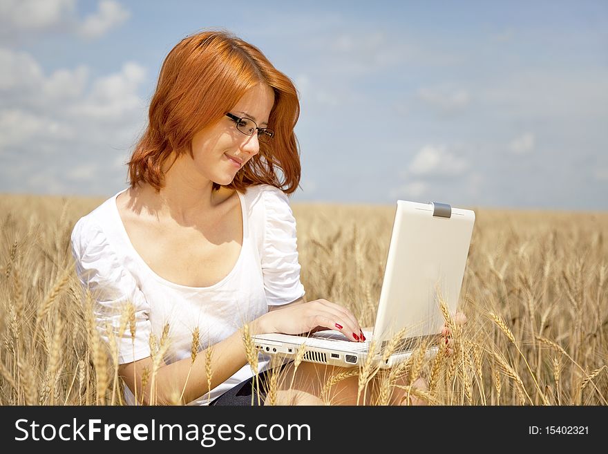 Young Businesswomen in white working with notebook at wheat field. Young Businesswomen in white working with notebook at wheat field.