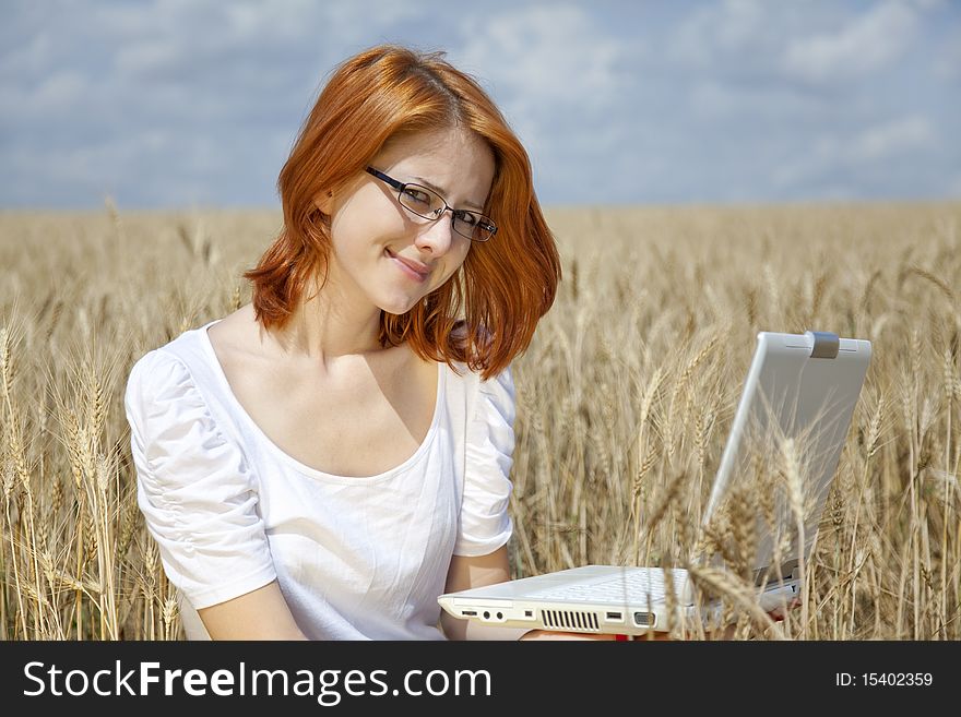 Young Businesswomen in white working with notebook at wheat field. Young Businesswomen in white working with notebook at wheat field.