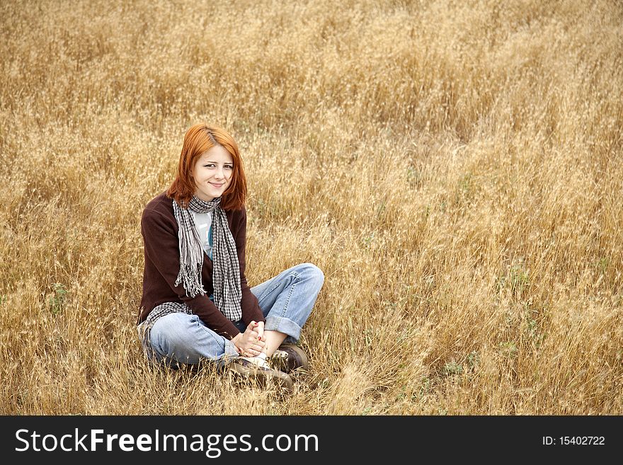 Beautiful Red-haired Girl At Yellow Autumn Grass.