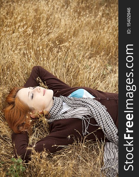 Young Beautiful Girl Lying At Yellow Autumn Field.